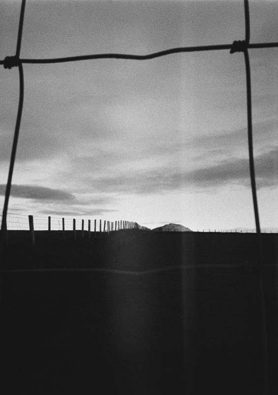 A hill seen through a fence