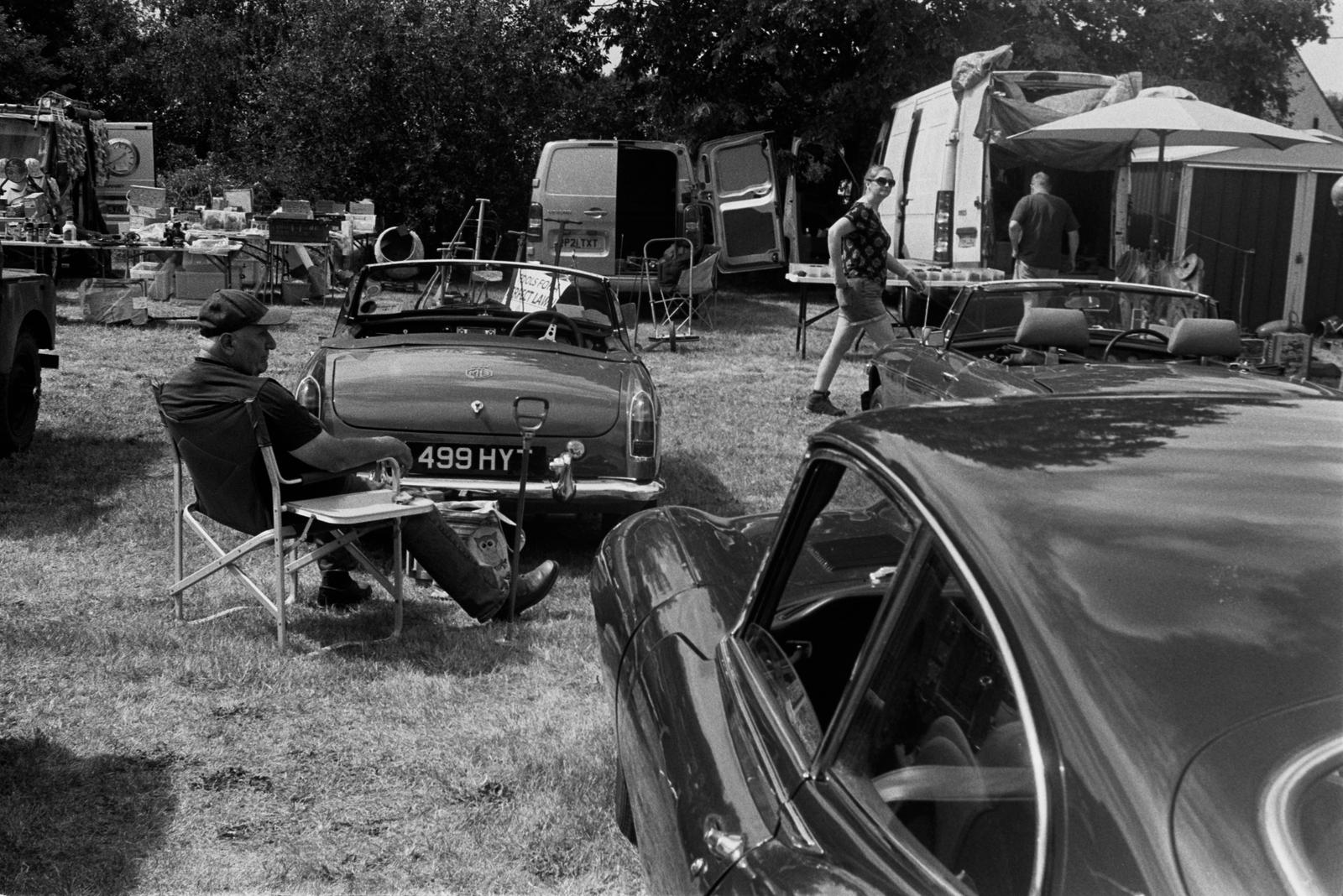A man sat by a car